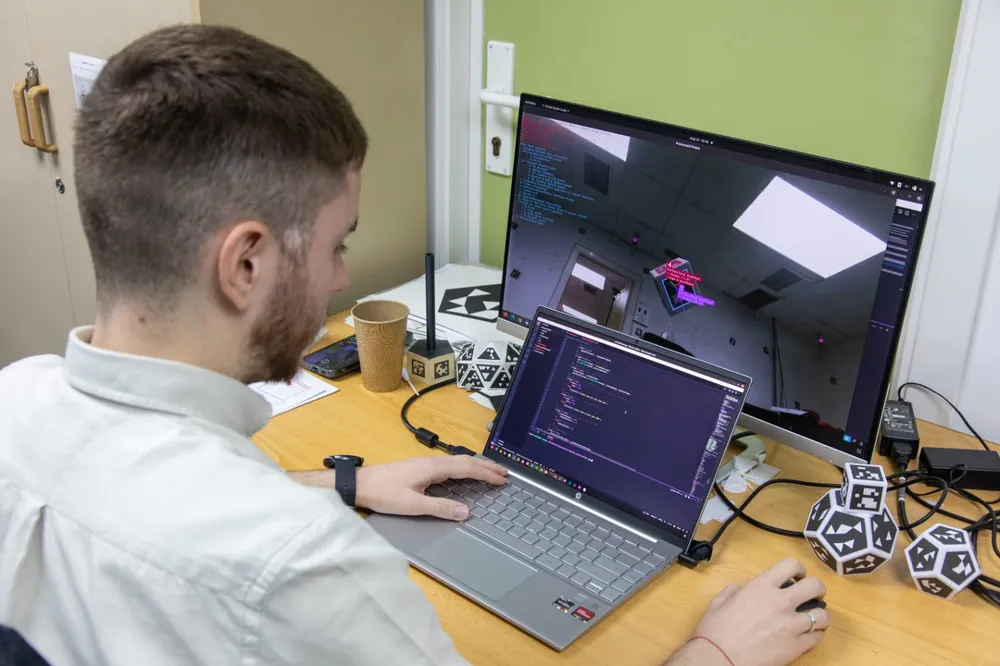 Pablo García Ruiz working with 3D-printed dodecahedron and icosahedron fiducial objects, with a real-time marker-detection overlay shown on screen.